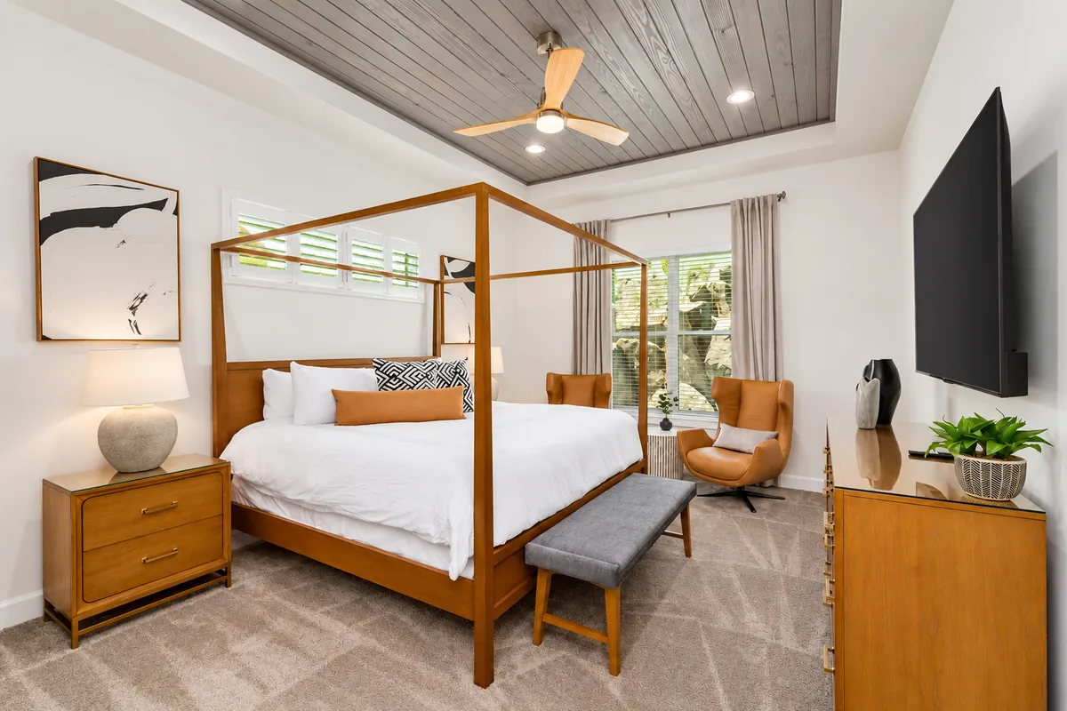Spacious bedroom with a wood canopy bed and comfortable seating