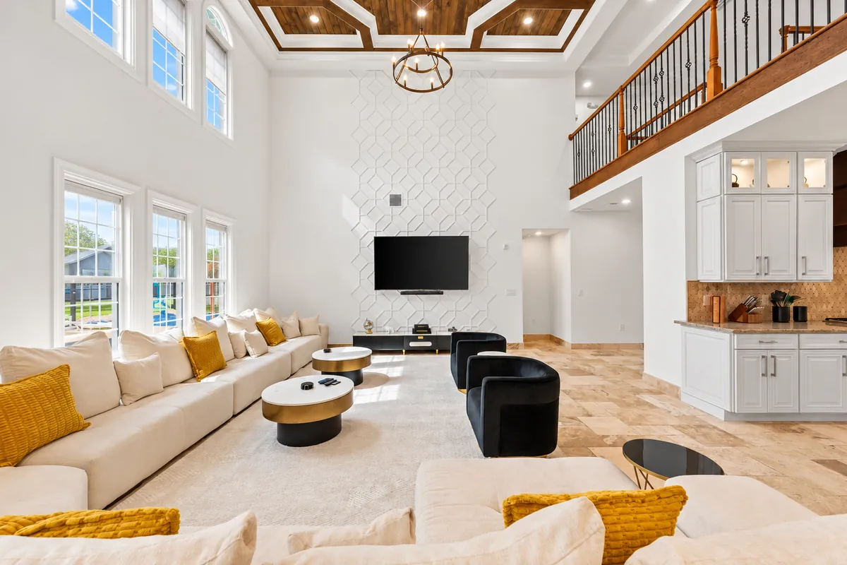 Double-height living room with comfortable seating and warm gold accents