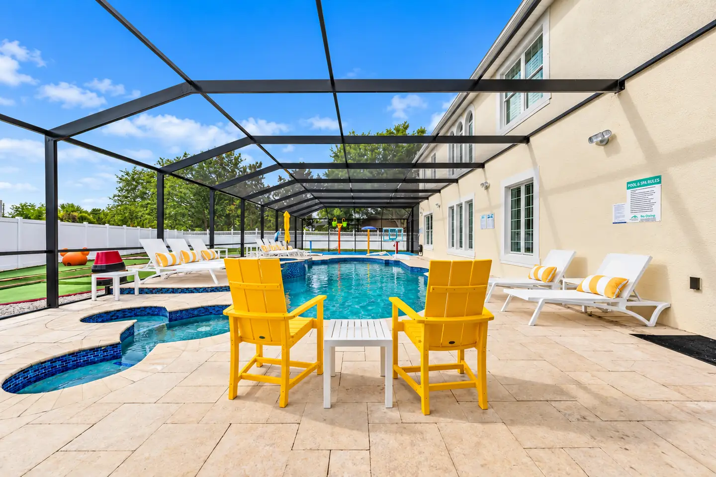 Yellow chairs beside a screened pool and spa at a Formosa Gardens vacation home