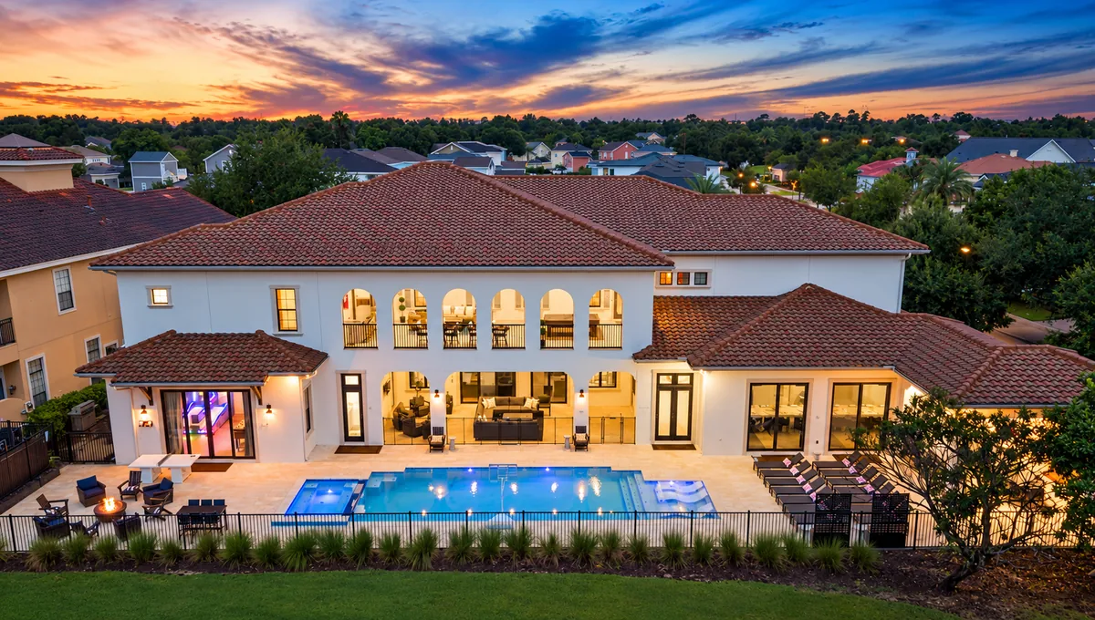 Large luxury Florida villa with an illuminated pool at dusk