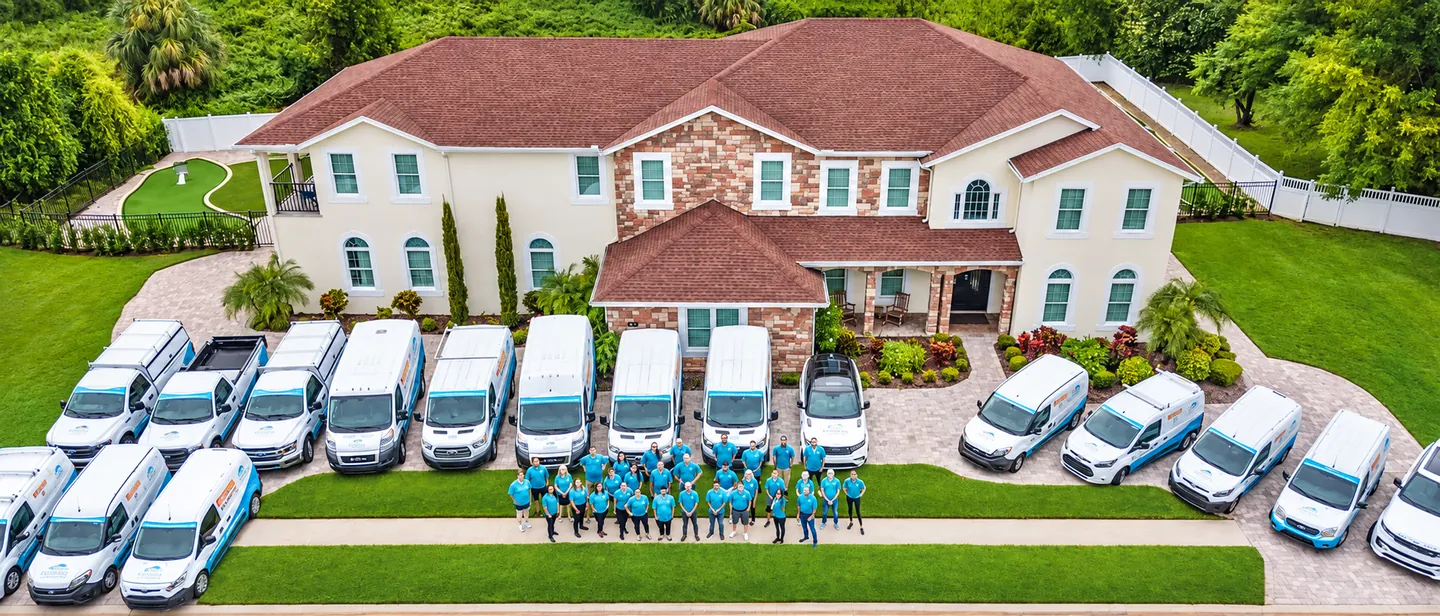 Vacation rental management team and service vehicles outside a luxury Florida home