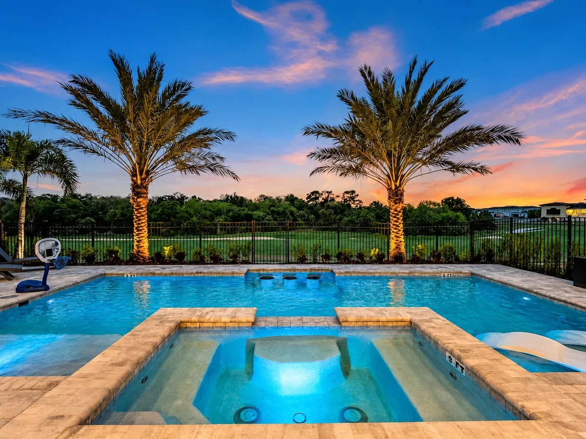 Private swimming pool and spa beneath palms at sunset