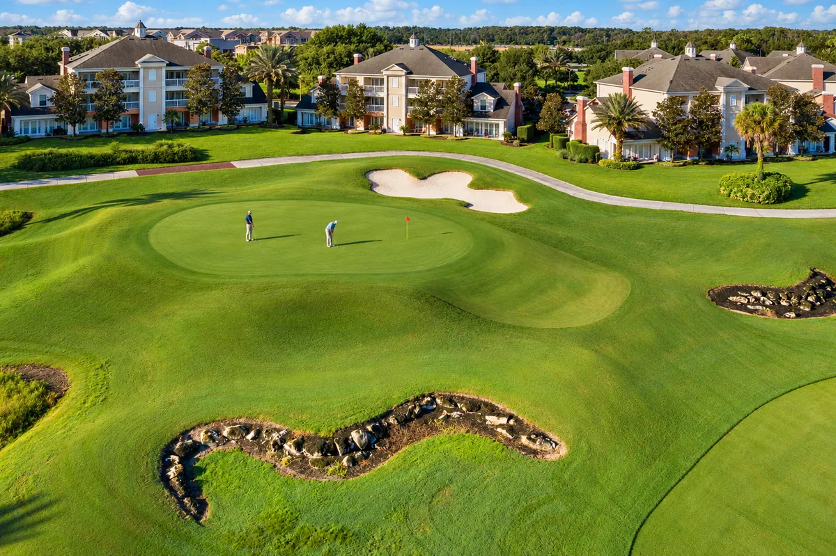 Golfers on a Reunion Resort green overlooking vacation homes