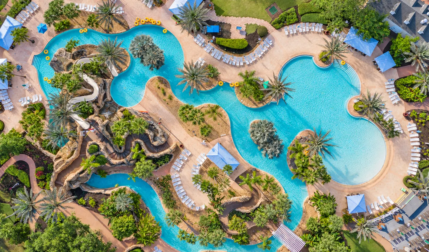 Aerial view of Reunion Resort water park, with turquoise pools, a lazy river, waterslides and palm trees