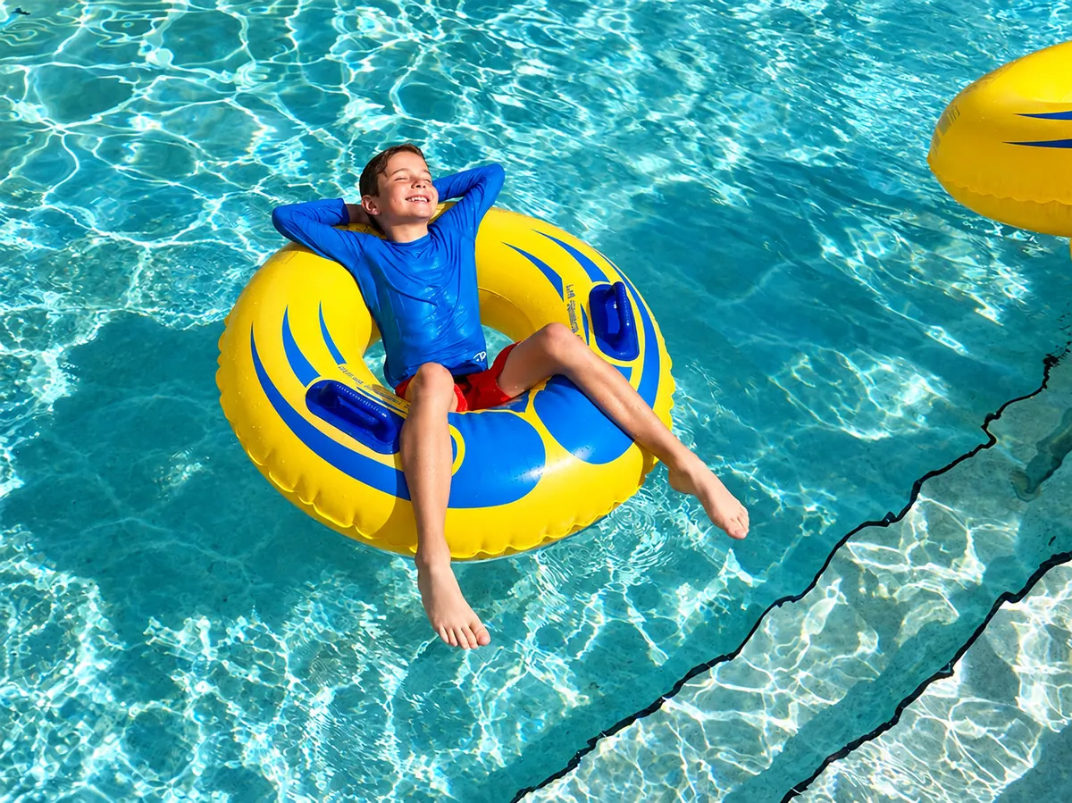 Child enjoying a carefree vacation moment on a yellow pool float