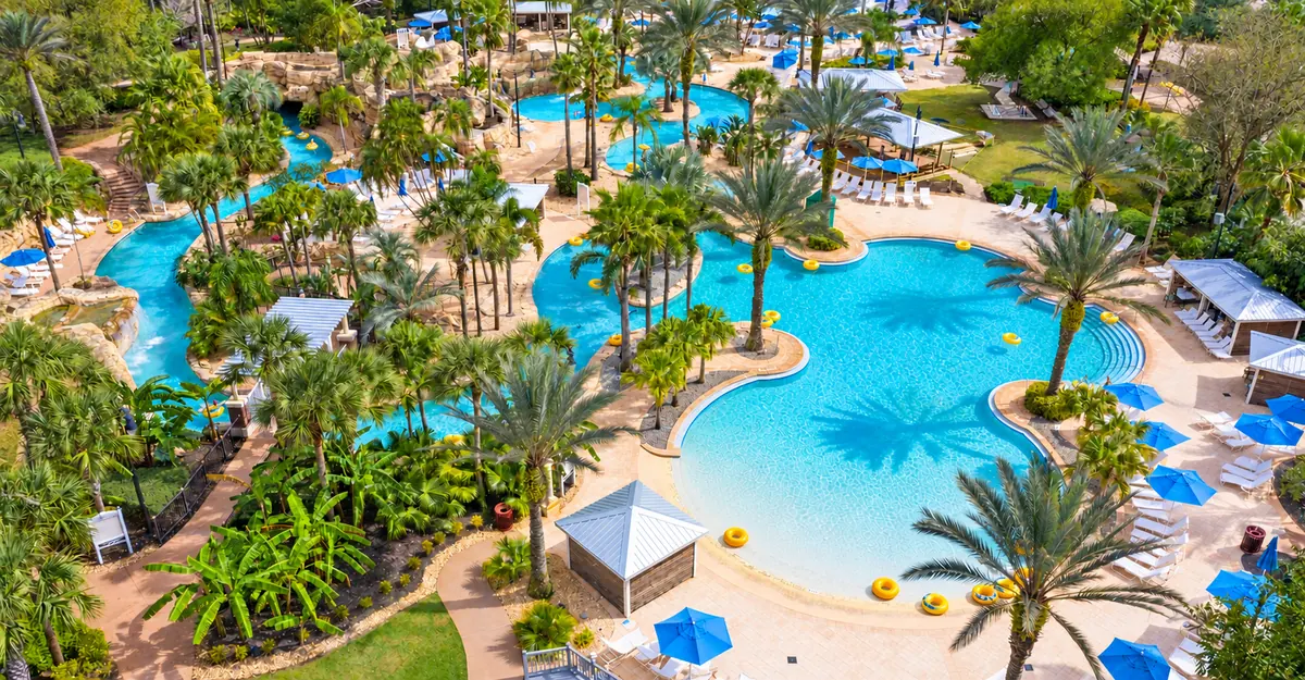 Reunion Resort water park with pools, lazy river, palms and blue umbrellas